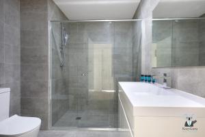a bathroom with a shower and a sink and a toilet at KozyGuru | Wentworthville | 2 Bed 2 Bath Apt in Wentworthville