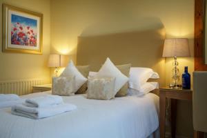 Un dormitorio con una cama blanca con toallas. en Derwent, en Keswick