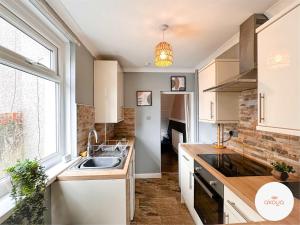 a kitchen with a sink and a window at Mariposa House - A Tasteful Escape in South Wales in Abertillery +5 photos