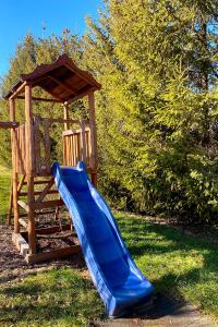 a blue slide next to a wooden playground at Csibi Apartman in Szilvásvárad +1 photo