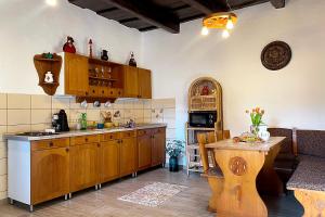 a kitchen with wooden cabinets and a wooden table at Csibi Apartman in Szilvásvárad