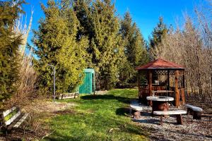 a park with a gazebo and benches in the grass at Csibi Apartman in Szilvásvárad