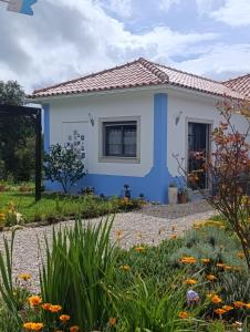 a blue and white house with a garden at Gîte CANTO AZUL in Casal da Carreira