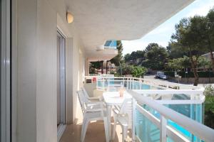 a white table and chairs on a balcony with a view at UHC Larimar Family Complex in Salou +35 photos
