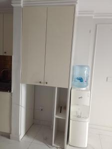 a white cabinet in a kitchen with a refrigerator at Effile view studio apartment in Lahore +2 photos