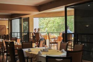a dining room with tables and chairs and a large window at Hotel Leonardo da Vinci in Santiago