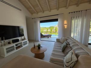 a living room with a couch and a flat screen tv at Villa Danai in Gouvia