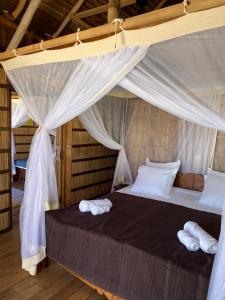a bedroom with a bed with white sheets and pillows at ENTREMER Maison du bout du monde in Belo