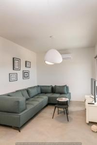 a living room with a green couch and a table at Rockaine Suites Echoes in Tinos