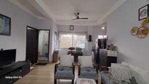 a living room with a couch and chairs and a tv at Vedic villa Apt in Siliguri
