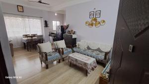 a living room with chairs and a couch and a table at Vedic villa Apt in Siliguri