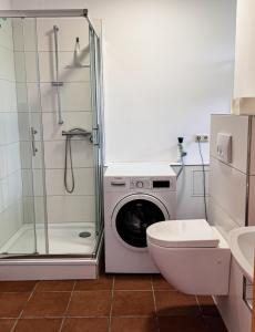a bathroom with a washing machine and a toilet at Haus 6-12P - 6Zi - Aurora Hamburg in Wenzendorf