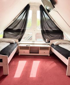 two beds in a room with a large window at Haus 6-12P - 6Zi - Aurora Hamburg in Wenzendorf