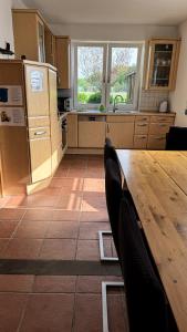 a kitchen with a wooden table and some chairs at Haus 6-12P - 6Zi - Aurora Hamburg in Wenzendorf