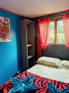 a bedroom with a bed with blue walls and a window at Hostal Vista Boquete in Boquete