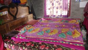 Postel nebo postele na pokoji v ubytování Tilak Homestay