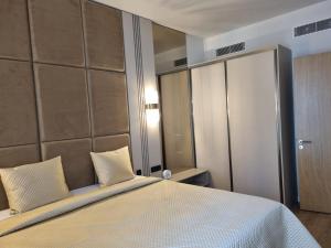 ティヴァトにあるBOKA PLACE One Bedroom Apartment NEWの大きなベッドと大きな鏡のある寝室 +6枚の写真