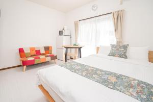 a hotel room with two beds and a chair at Shinjuku Terrace 226 BnB in Tokyo