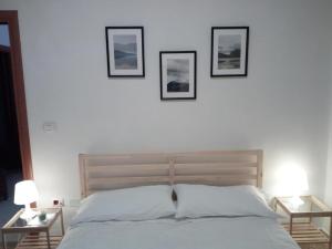 a bedroom with a bed with three pictures on the wall at Montesanto 116 in Cosenza