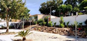 a house with a fence and a pile of rocks at Quinta Castilho in Fortes de Cima