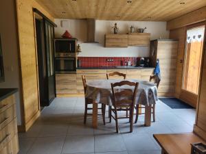kuchnia ze stołem i krzesłami w pokoju w obiekcie Appartement cosy face aux Aravis w mieście Le Grand-Bornand