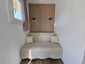 a couch in a corner of a room with a window at Chez Adriana Studio VUE MER avec Piscine in Grimaud +15 photos