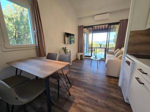 a small kitchen and living room with a table and chairs at Chez Adriana Studio VUE MER avec Piscine in Grimaud