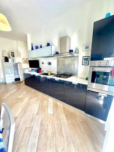 a large kitchen with stainless steel appliances and wooden floors at La casa del mare in Marina dʼAndora