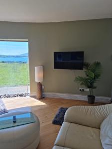 a living room with a couch and a flat screen tv at Fab View in Dingle