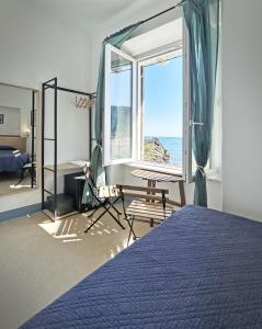 a bedroom with a bed and a large window at Hotel Meublè Agavi in Monterosso al Mare