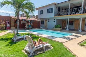 a woman laying in a lawn chair next to a swimming pool at Coccoloba Guest House in Puerto Escondido