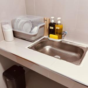 Sampongdebzyph lovely home的带有水槽和碗碟容器的厨房柜台