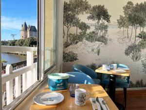 a dining room with a window with a view of a castle at Hôtel Beau Soleil in Pornic