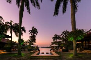 een resort met palmbomen en een zwembad bij zonsondergang bij Zimbali Lodge by Dream Resorts in Ballito
