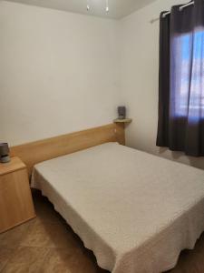 une petite chambre avec un lit et une fenêtre dans l'établissement linguizzetta , les marines de bravone, à Linguizzetta