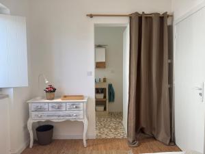 a door leading into a bedroom with a dresser and a mirror at Casa Pompilio in Sagres
