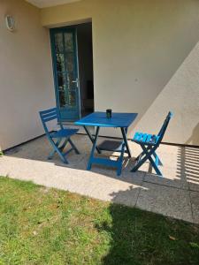 Una mesa de picnic azul y dos sillas al lado de un edificio. en Studio, en Talmont