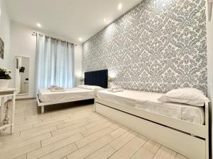 a bedroom with two beds and a wall mural at lungomare rooms in Castellammare di Stabia