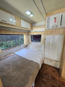 a small bedroom with a bed in an rv at La Brume Trailers in Campos do Jordão