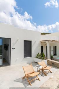 a patio with two chairs and a table at Rockaine Suites Eclipse in Tinos
