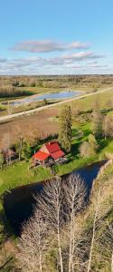 an aerial view of a farm with a house and a lake at Brīvdienu māja Straumēni in Pāle