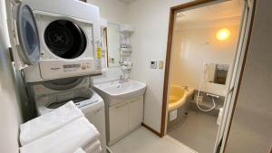 a bathroom with a sink and a washing machine at 本部コテージnobaru in Motobu