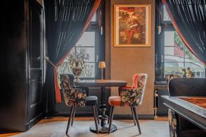 a table and two chairs in a room with a window at Boutique Pension Code Rosé in Noordwijk