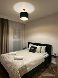 a bedroom with a bed with two towels on it at Apartament GB przy PCK 5 z bezpłatnym parkingiem by Gingerbread Apartments in Toruń