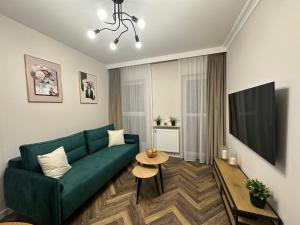a living room with a green couch and a table at Apartament GB przy PCK 5 z bezpłatnym parkingiem by Gingerbread Apartments in Toruń +83 photos