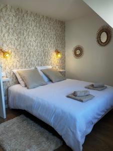 滨海布隆维尔Le Cottage D'Ilona的卧室里有一张大床，床上铺着毛巾。