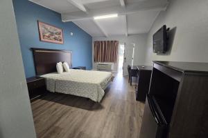 una camera d'albergo con un letto e una televisione di Luxury Inn & Suites a Nacogdoches Altre 2 foto