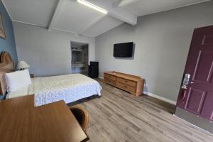 una camera d'albergo con un letto e una tv di Luxury Inn & Suites a Nacogdoches