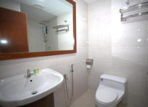 a bathroom with a sink and a toilet and a mirror at Orkid Hills Hotel at Bukit Bintang in Kuala Lumpur +27 photos