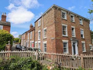 a brick building with a fence in front of it at Middle Cottage in Louth